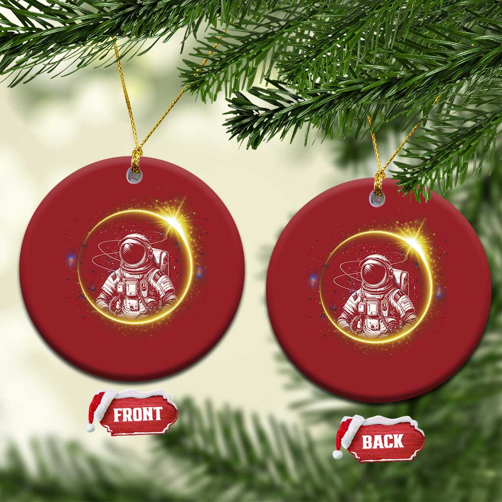 Two red round astronaut Christmas ornaments with glowing space art and gold hanging loop