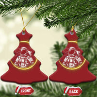 Two red tree-shaped astronaut Christmas ornaments with glowing space art and gold hanging loops