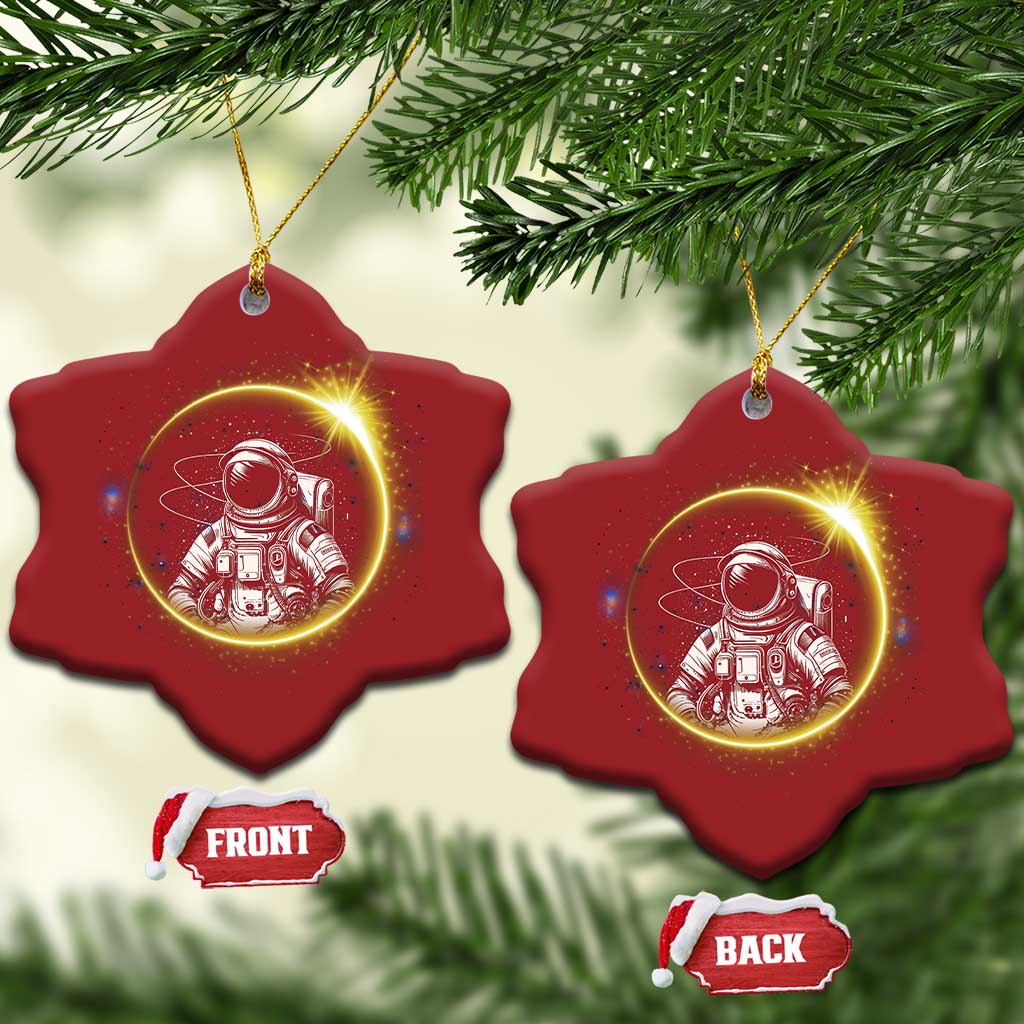 Two red star-shaped astronaut Christmas ornaments with glowing space scene and gold hanging loops