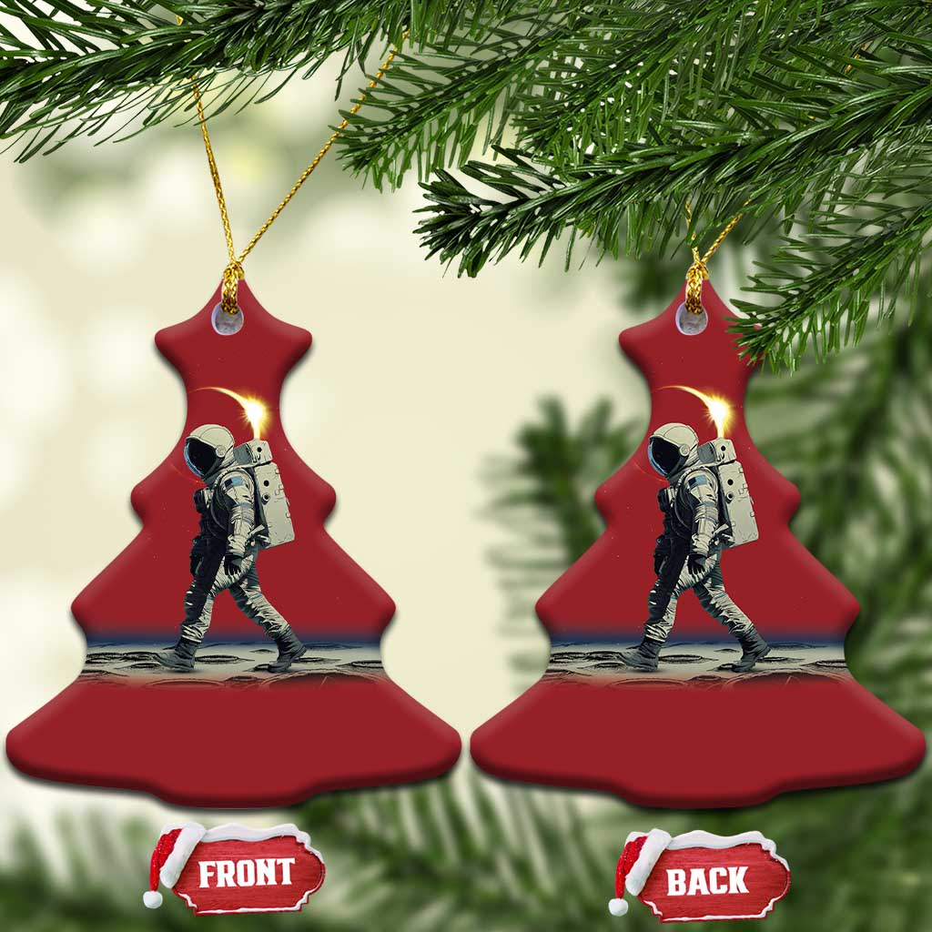 Two red bell-shaped astronaut ornaments with gold hangers and a printed space scene