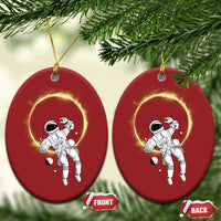 Set of two red oval astronaut ornaments with glowing halo rings, hanging on gold strings