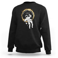 Black crewneck sweatshirt with astronaut total solar eclipse graphic on chest
