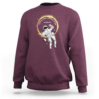 Maroon crewneck sweatshirt with astronaut total solar eclipse graphic on chest