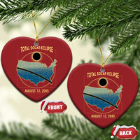 Two red heart-shaped solar eclipse map Christmas ornaments with gold hanging loops