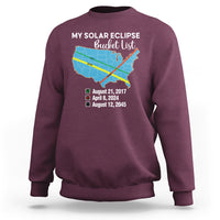 Maroon crewneck sweatshirt with eclipse map graphic and event dates on back