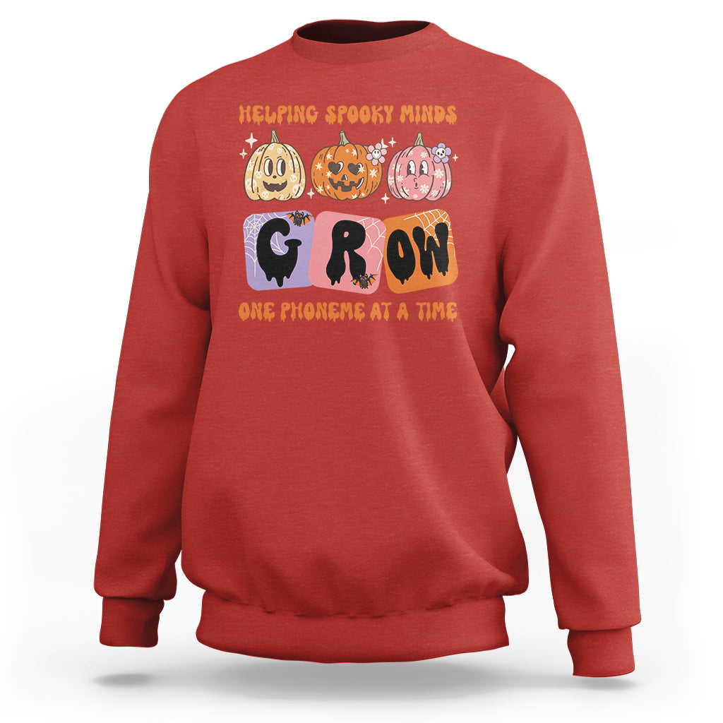 Red Halloween reading sweatshirt with “GROW” phoneme graphic and orange text