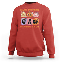 Red Halloween reading sweatshirt with “GROW” phoneme graphic and orange text