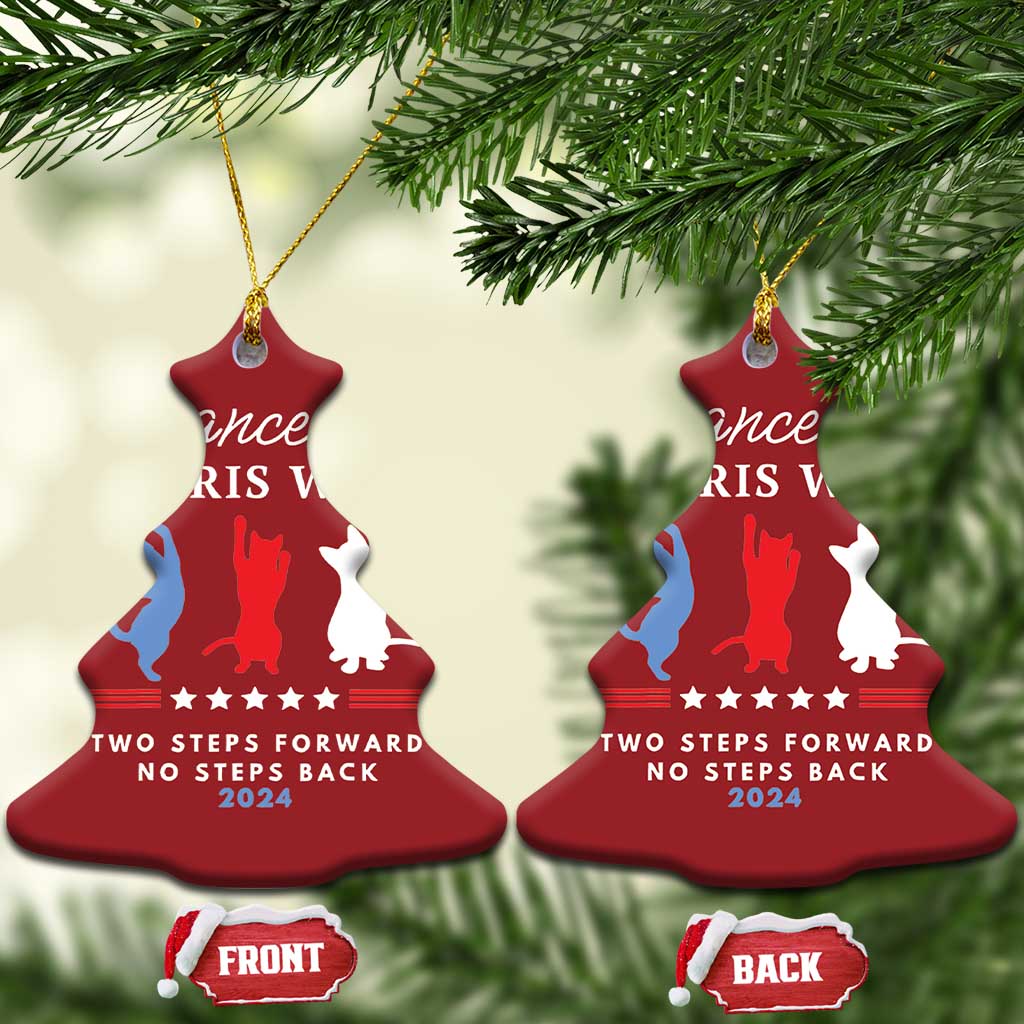 Two red bell-shaped Christmas ornaments with dancer silhouettes and front/back labels on pine