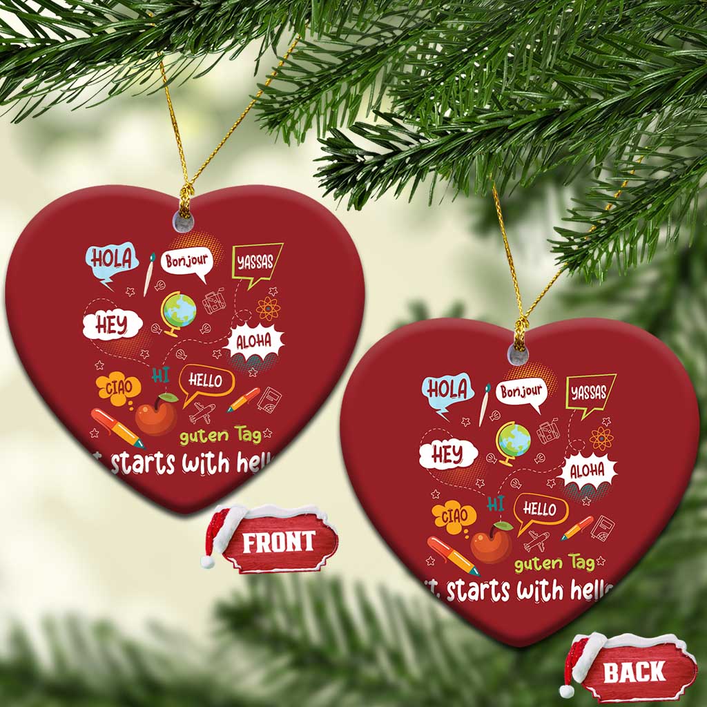 Two red heart-shaped Christmas ornaments with “it starts with hello” multilingual greetings, gold strings.