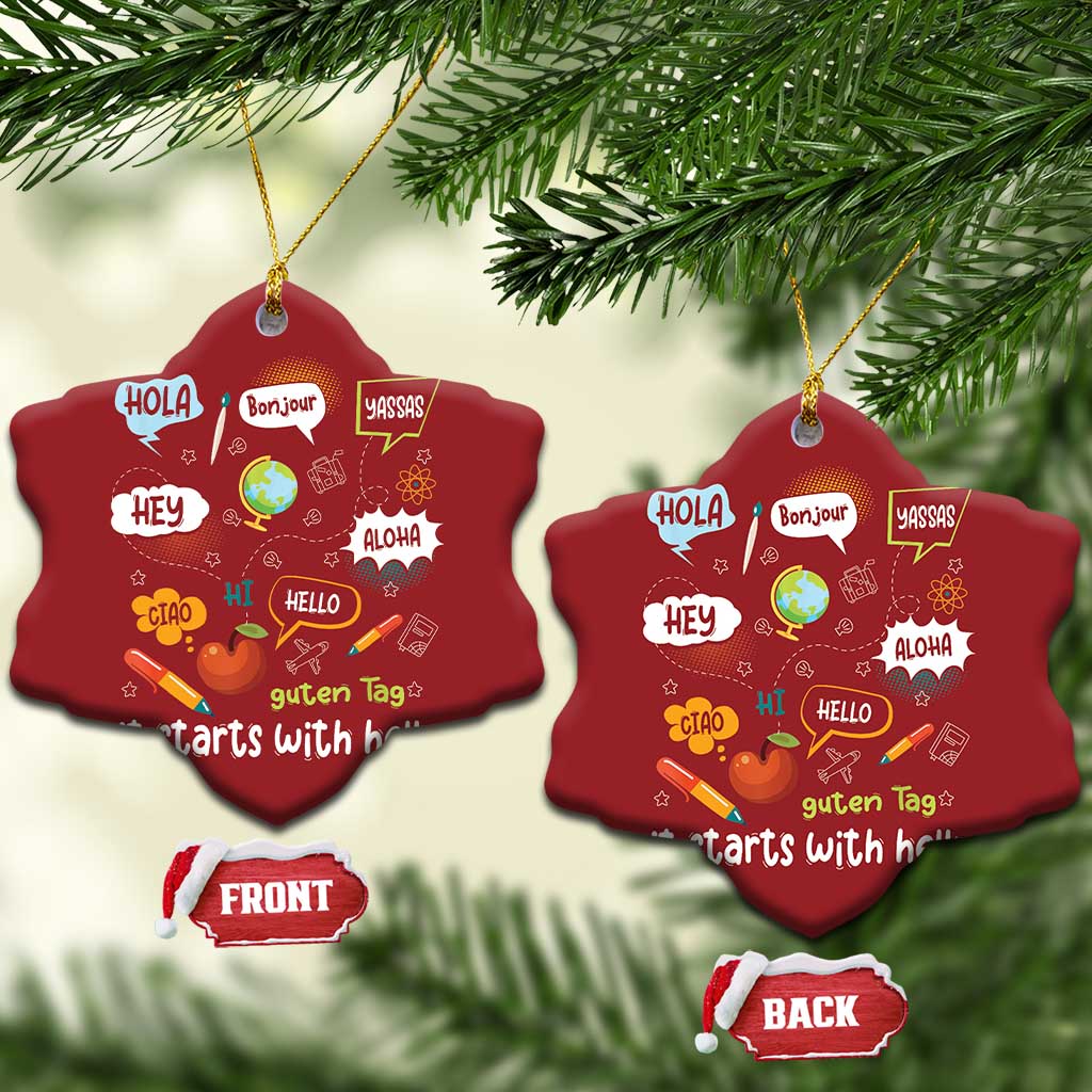 Two red heart-shaped Christmas ornaments with “it starts with hello” greeting text and gold strings.