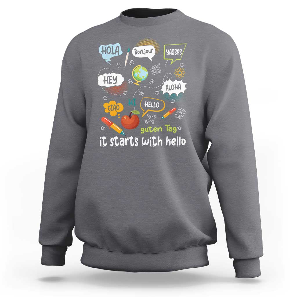 Inclusion Matters sweatshirt, charcoal crewneck with colorful multilingual “it starts with hello” graphic