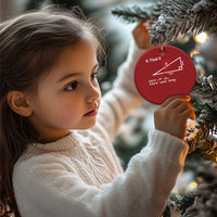 Red round Christmas ornament with '6. Find X' math diagram, child holding it near tree.