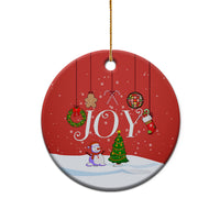 Round red “JOY” ceramic ornament with gold hanging loop, white snow base.