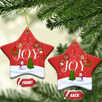 Red star-shaped ceramic ornaments with “JOY” scene, gold hanging loops, front/back labels.
