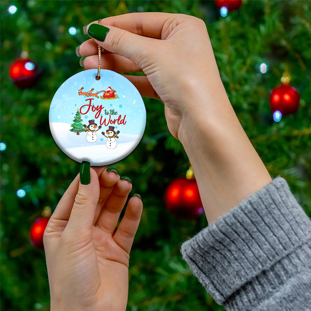 Blue ceramic circular ornament with Joy to the World text, sleigh, and snowmen.