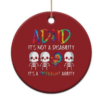Red round ADHD awareness ornament with colorful text and skull graphic, hanging loop.