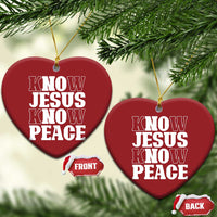 Two red heart-shaped Christmas ornaments with white “KNOW JESUS KNOW PEACE” text, gold strings.