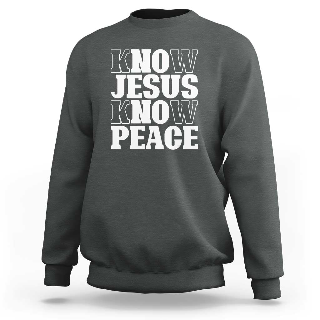 Dark heather crewneck sweatshirt with "KNOW JESUS KNOW PEACE" graphic on the front.