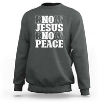 Dark heather crewneck sweatshirt with "KNOW JESUS KNOW PEACE" graphic on the front.