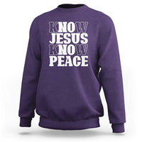 Purple crewneck sweatshirt with "KNOW JESUS KNOW PEACE" graphic on the front.