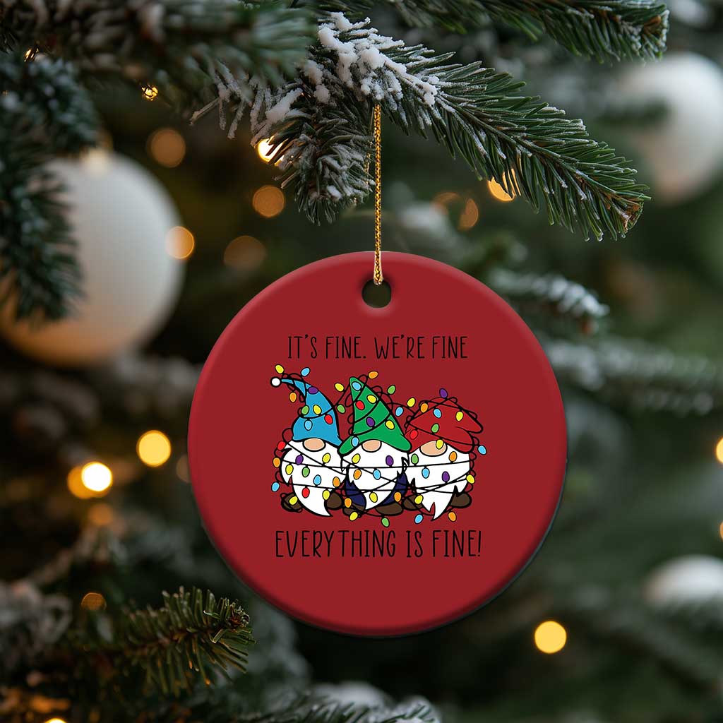 Red round Christmas ornament with gnome illustration, gold hanging string on tree