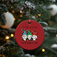 Red round Christmas ornament with gnome illustration, gold hanging string on tree
