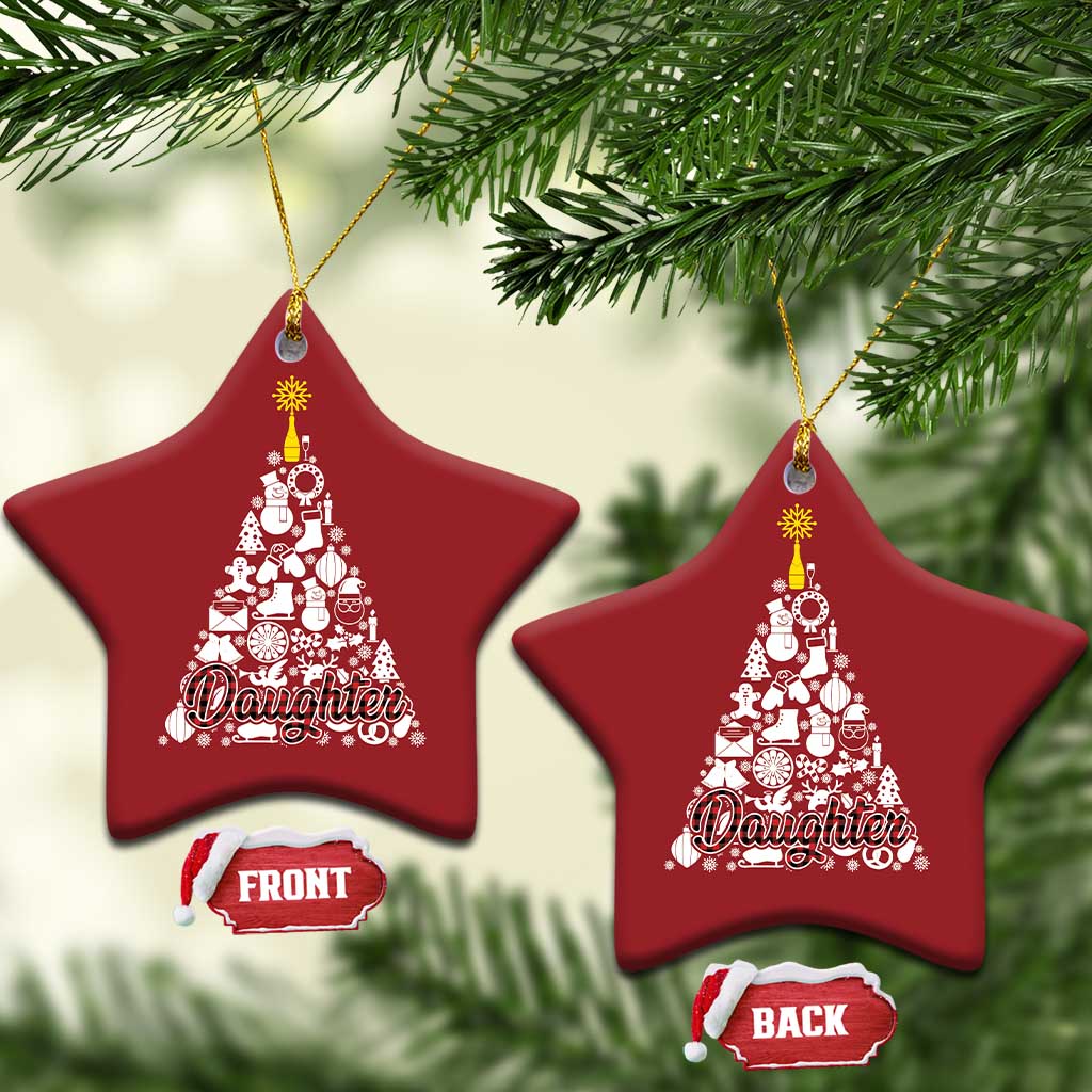Two red star-shaped Christmas ornaments hanging with gold hooks and white "Daughter" design