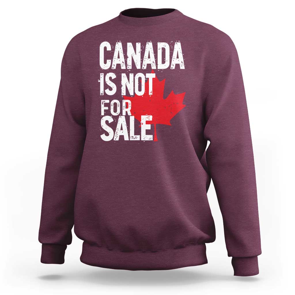 Maroon crewneck sweatshirt with distressed 'Canada is not for sale' text and red maple leaf.