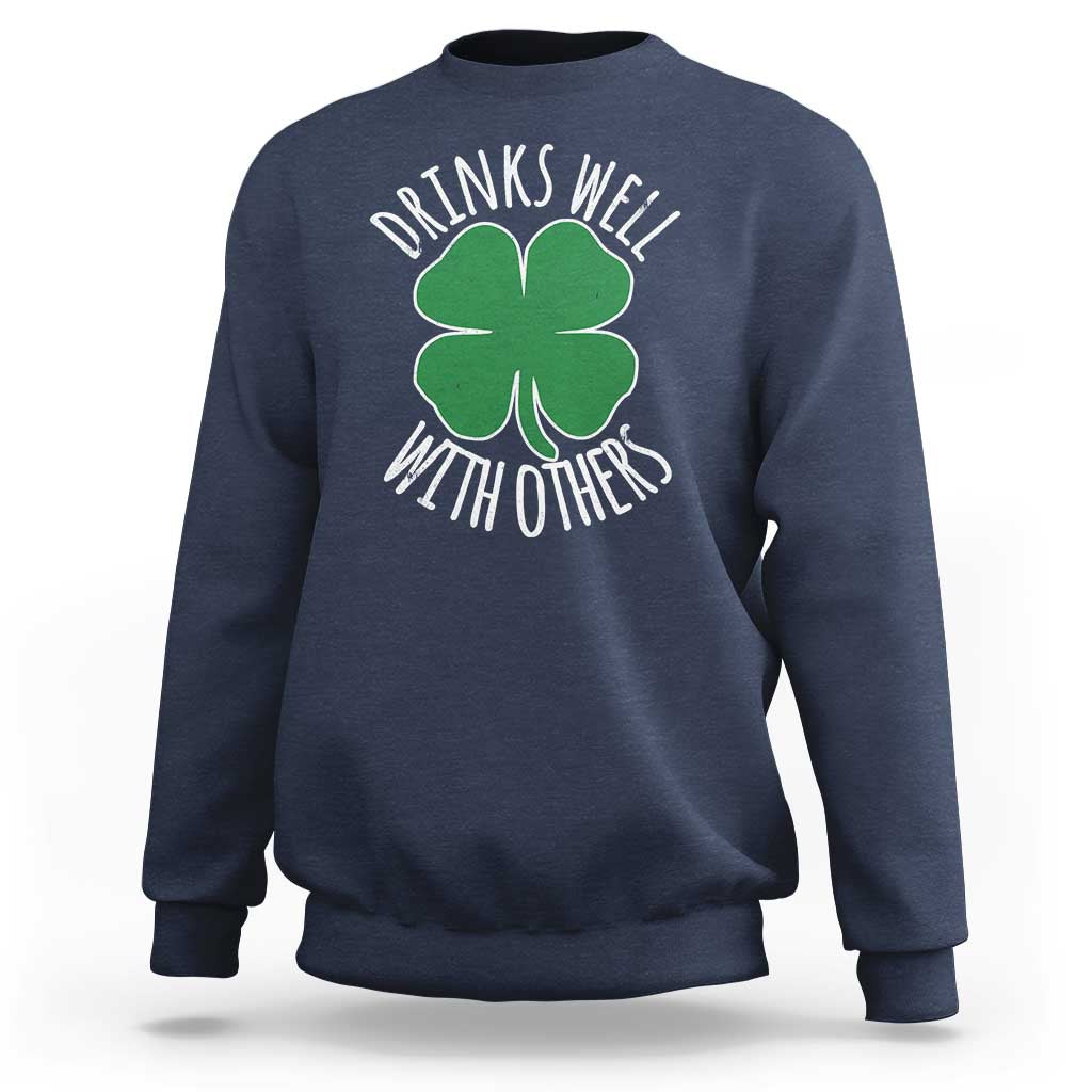 Navy crewneck sweatshirt with green shamrock graphic and 'Drinks well with others' text