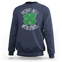 Navy crewneck sweatshirt with green shamrock graphic and 'Drinks well with others' text