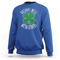 Royal blue crewneck sweatshirt with green shamrock graphic and 'Drinks well with others' text