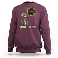 Solar eclipse skeleton sweatshirt in maroon with gold graphic and date 4.08.24