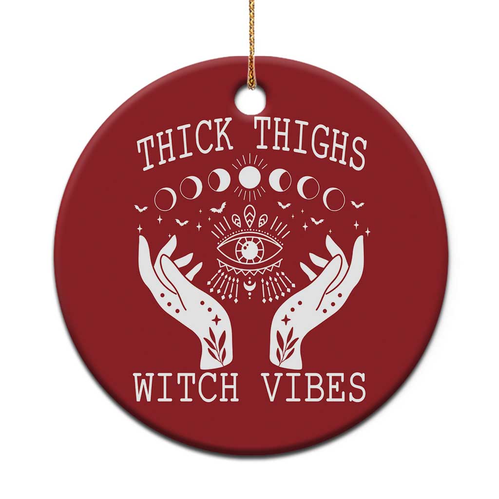 Red round witch vibe ornament with hanging string; white moon-phase eye and hands graphic