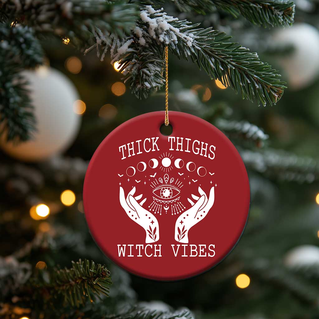 Red round witch vibe ornament with hanging string; white moon-phase eye and hands graphic