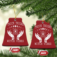 Two red bell-shaped witch vibe ornaments with hanging strings; moon-phase eye and hands graphics