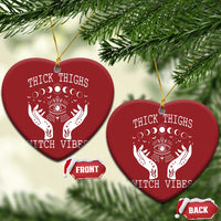 Two red heart-shaped witch vibe ornaments with hanging strings; moon-phase eye and hands graphic