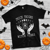 Black crew-neck T-shirt with white moon-phase eye and hands graphic, "Witch Vibes" text