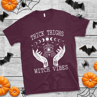 Maroon crew-neck T-shirt with white moon-phase eye and hands graphic, "Witch Vibes" text