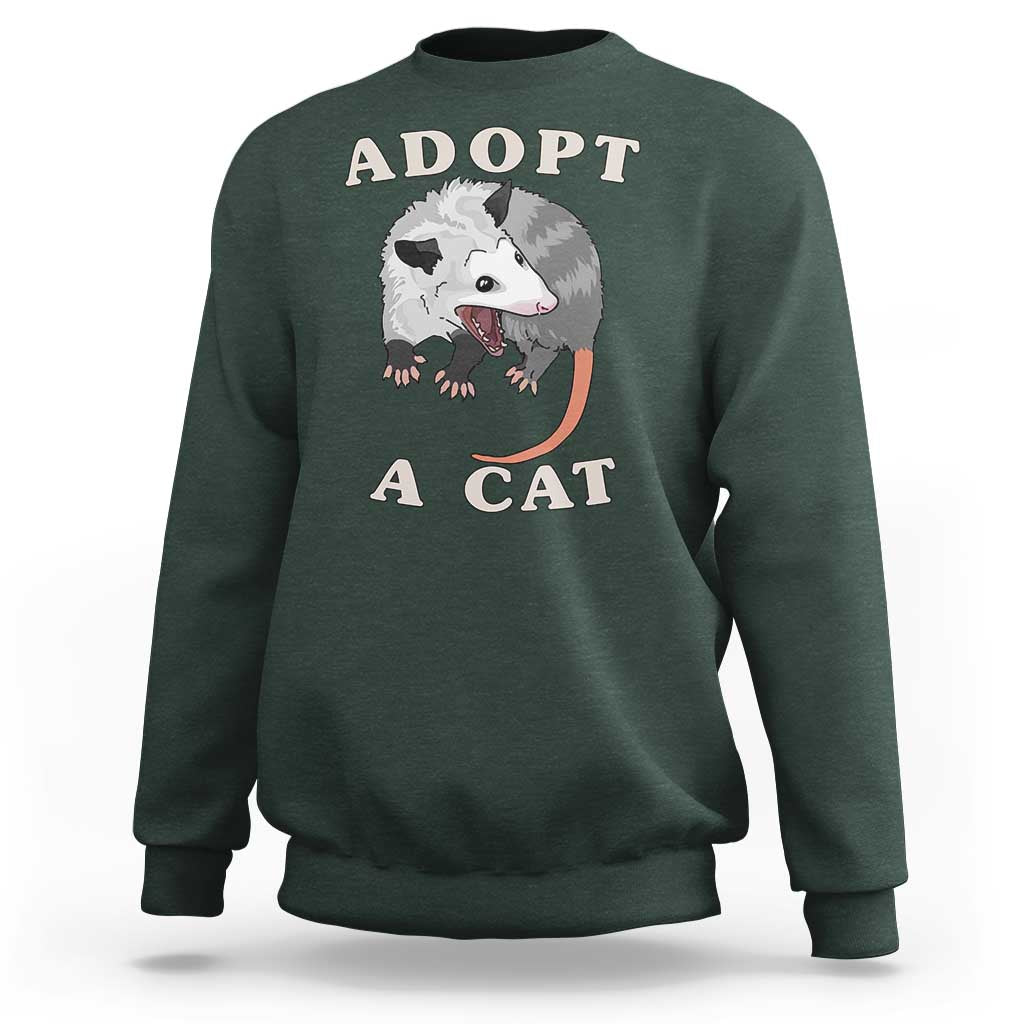 Dark forest green sweatshirt with 'ADOPT A CAT' graphic on front, crewneck long sleeves