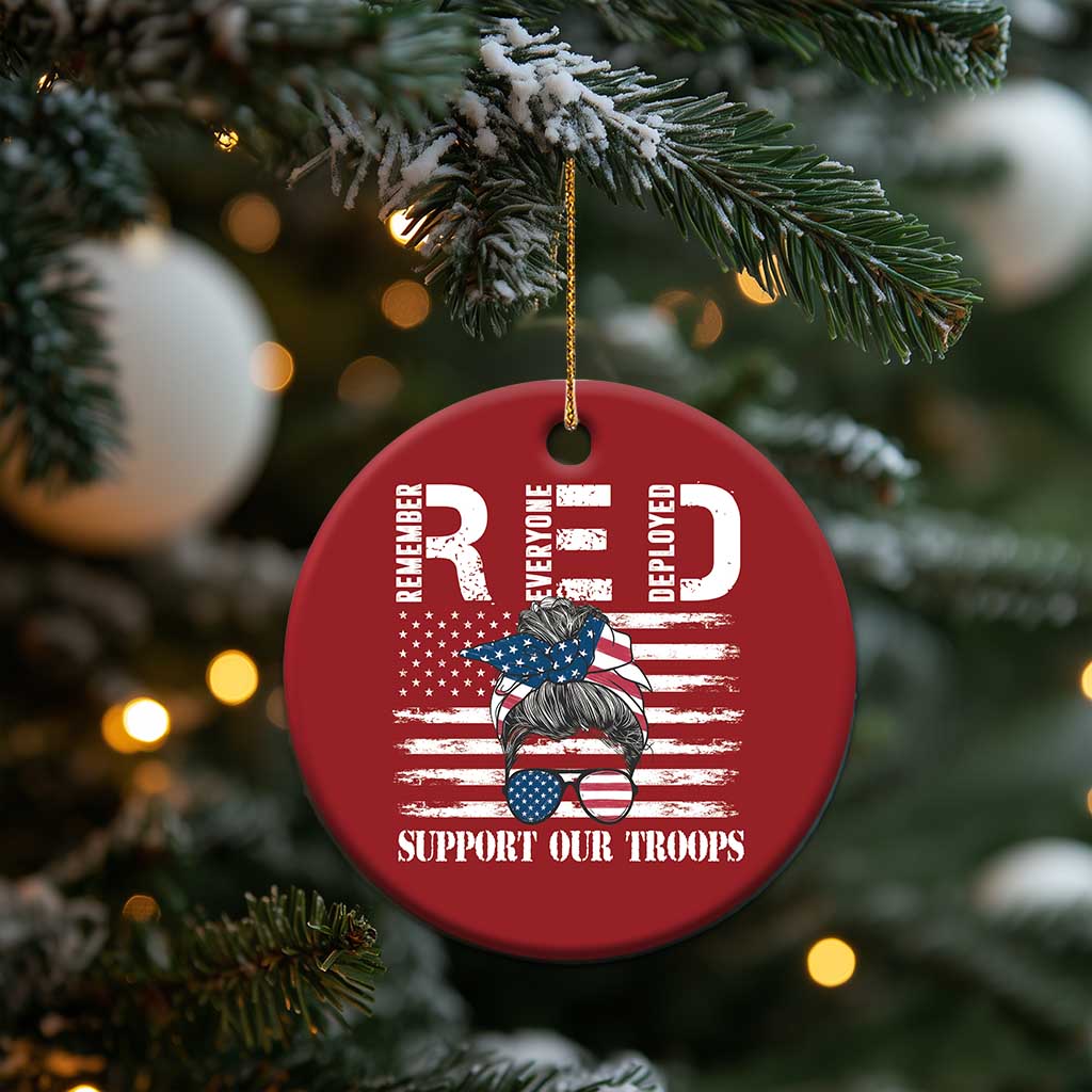 Red round Christmas ornament hanging from gold string with “Support Our Troops” graphic