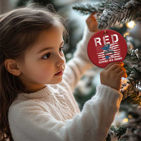 Red round Christmas ornament hanging on tree branches with gold loop
