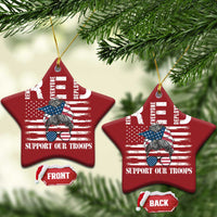 Red star-shaped Christmas ornaments with gold loops and “Support Our Troops”