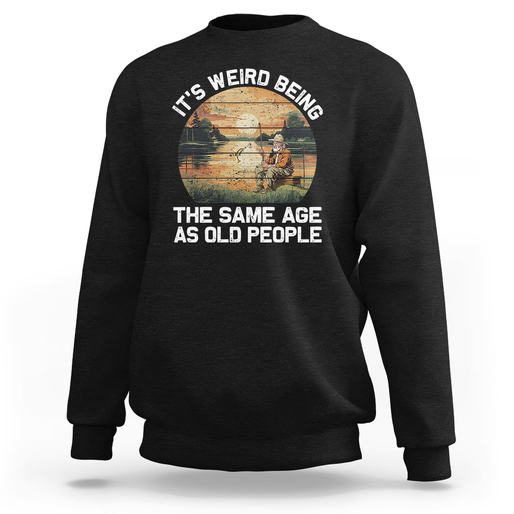 Black crewneck sweatshirt with front fishing-themed slogan graphic, long sleeves.