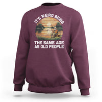 Maroon crewneck sweatshirt with front fishing-themed slogan graphic, long sleeves.