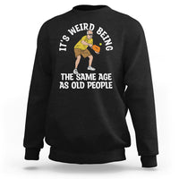 Black crewneck sweatshirt with pickleball graphic and the phrase “THE SAME AGE AS OLD PEOPLE”.