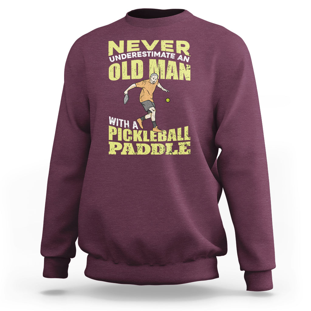 Maroon sweatshirt with crew neck and front pickleball paddler graphic