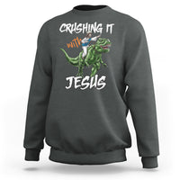 Dark heather crewneck sweatshirt with dinosaur graphic and text "CRUSHING IT with JESUS"