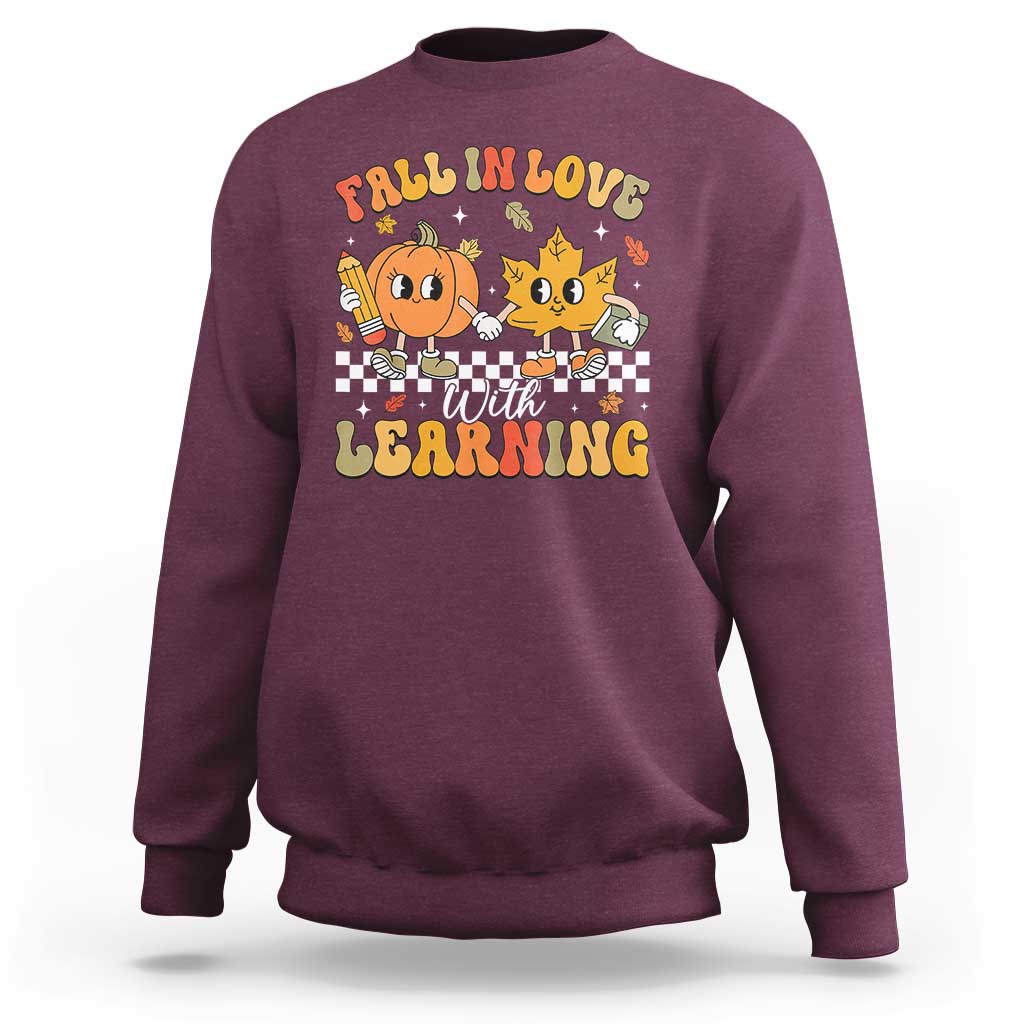 Maroon crewneck sweatshirt with fall learning cartoon graphic on chest