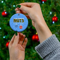 Blue ceramic round Christmas ornament with “NUTS” text and hanging bauble icons.