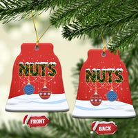Red ceramic bell-shaped Christmas ornament with “NUTS” and gold hanging string.